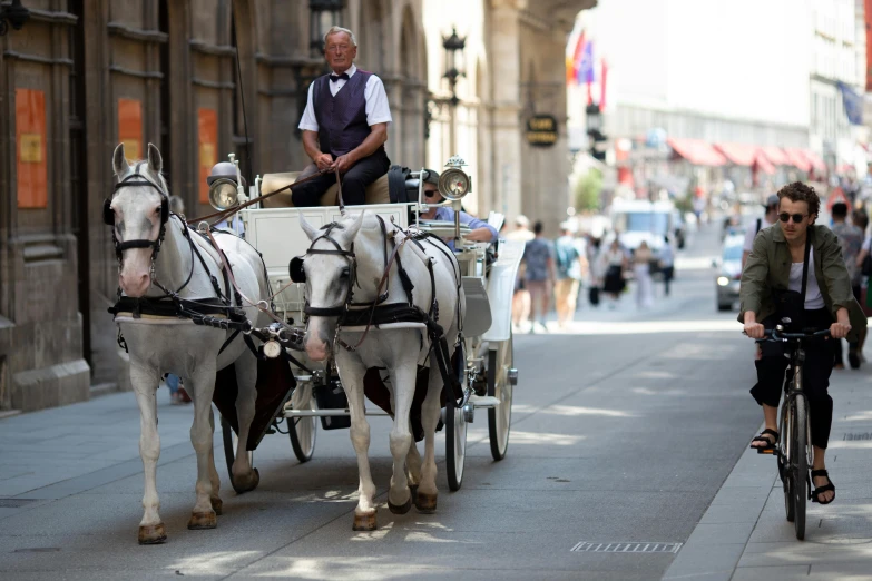 people riding bicycles with two horse and carriages