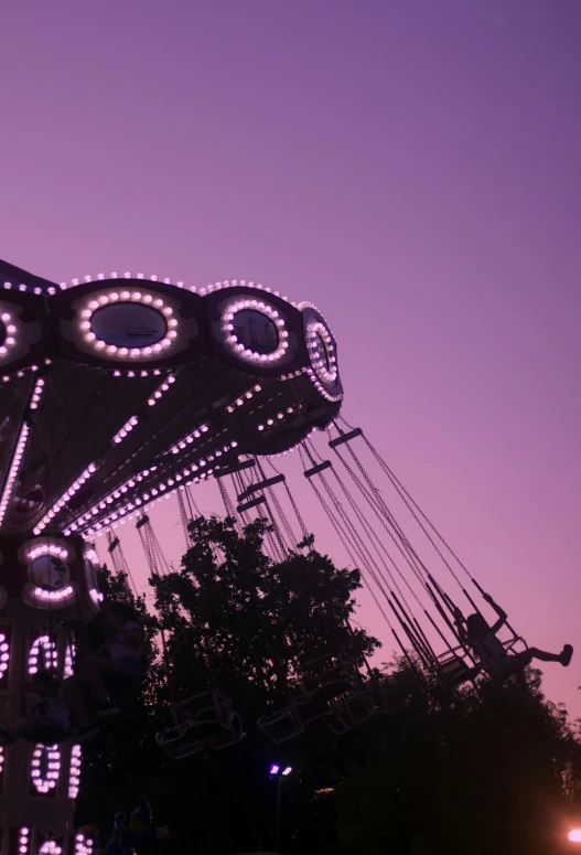 a merry go round ride at dusk in the middle of the day