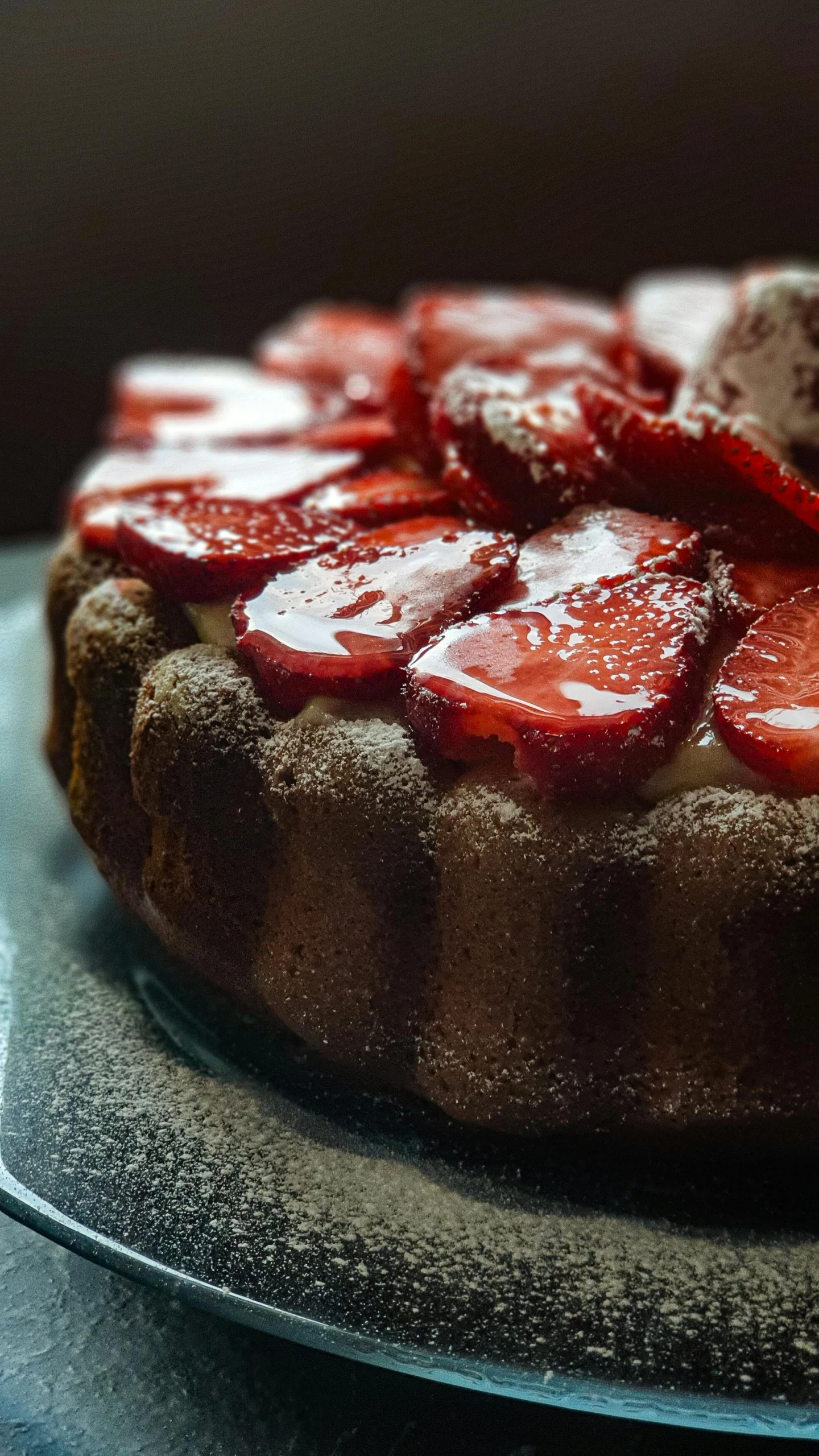 a cake is adorned with chocolate and sliced strawberries