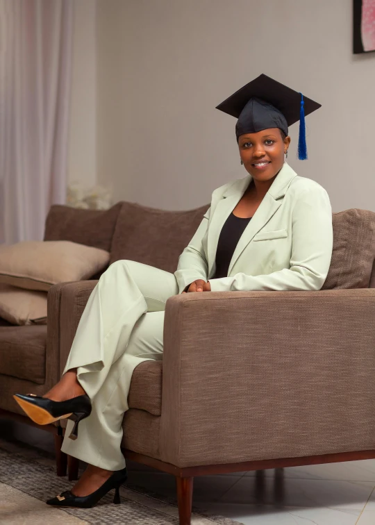 a woman sits on a couch wearing a hat