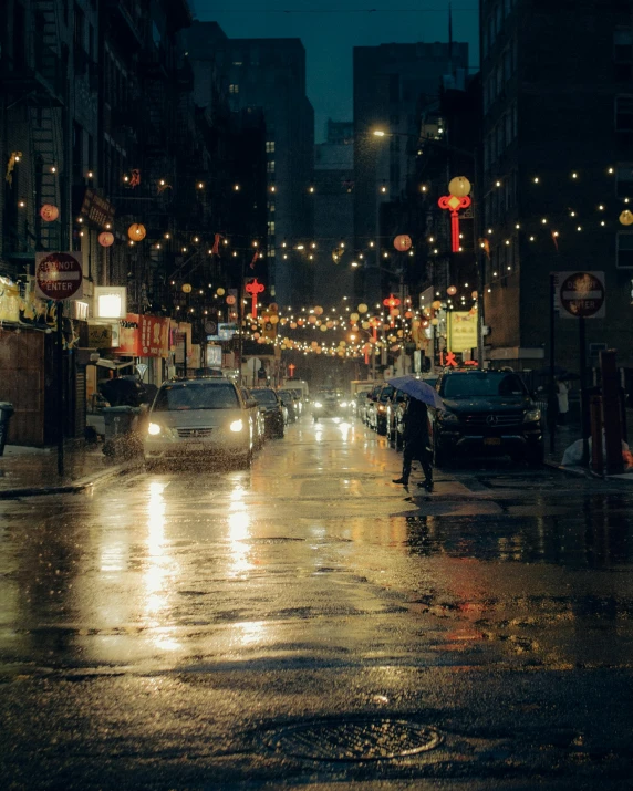 a rainy night shows cars, buildings and street lights