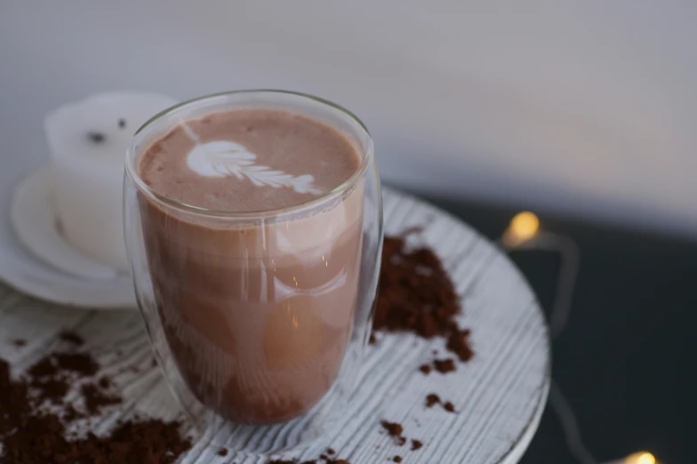 a cup of  cocoa with a feather decoration