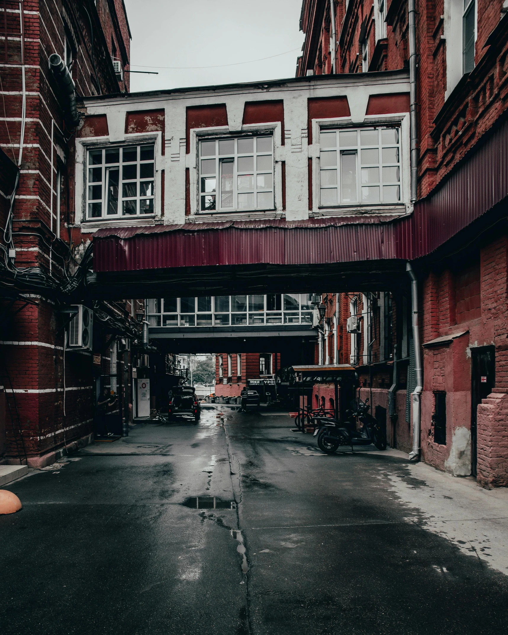 an alley way with several large windows and cars