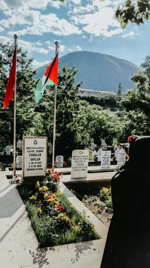 a monument with flowers and flags in it