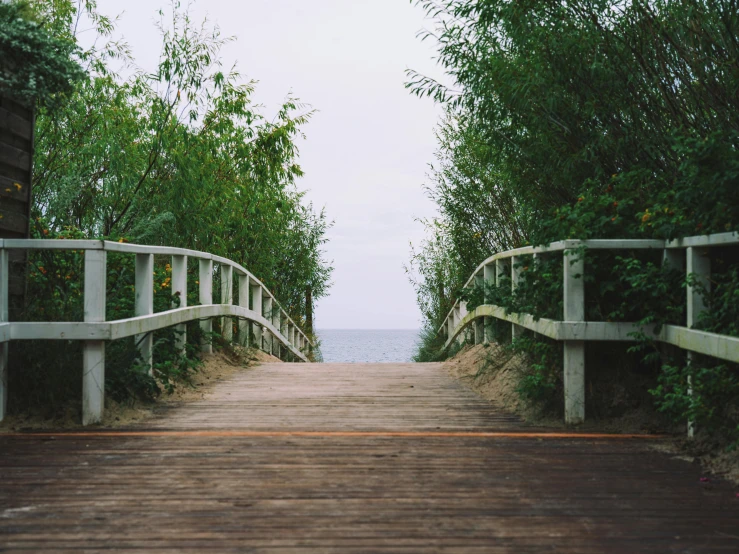 a wooden walkway going up to the ocean