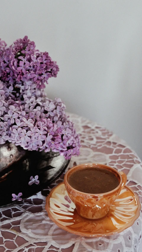 coffee is served with a large bouquet of lilacs