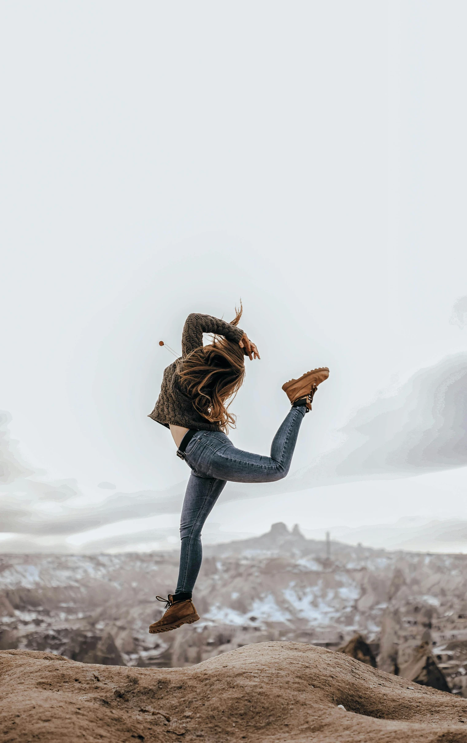 a girl jumping in the air on a rock