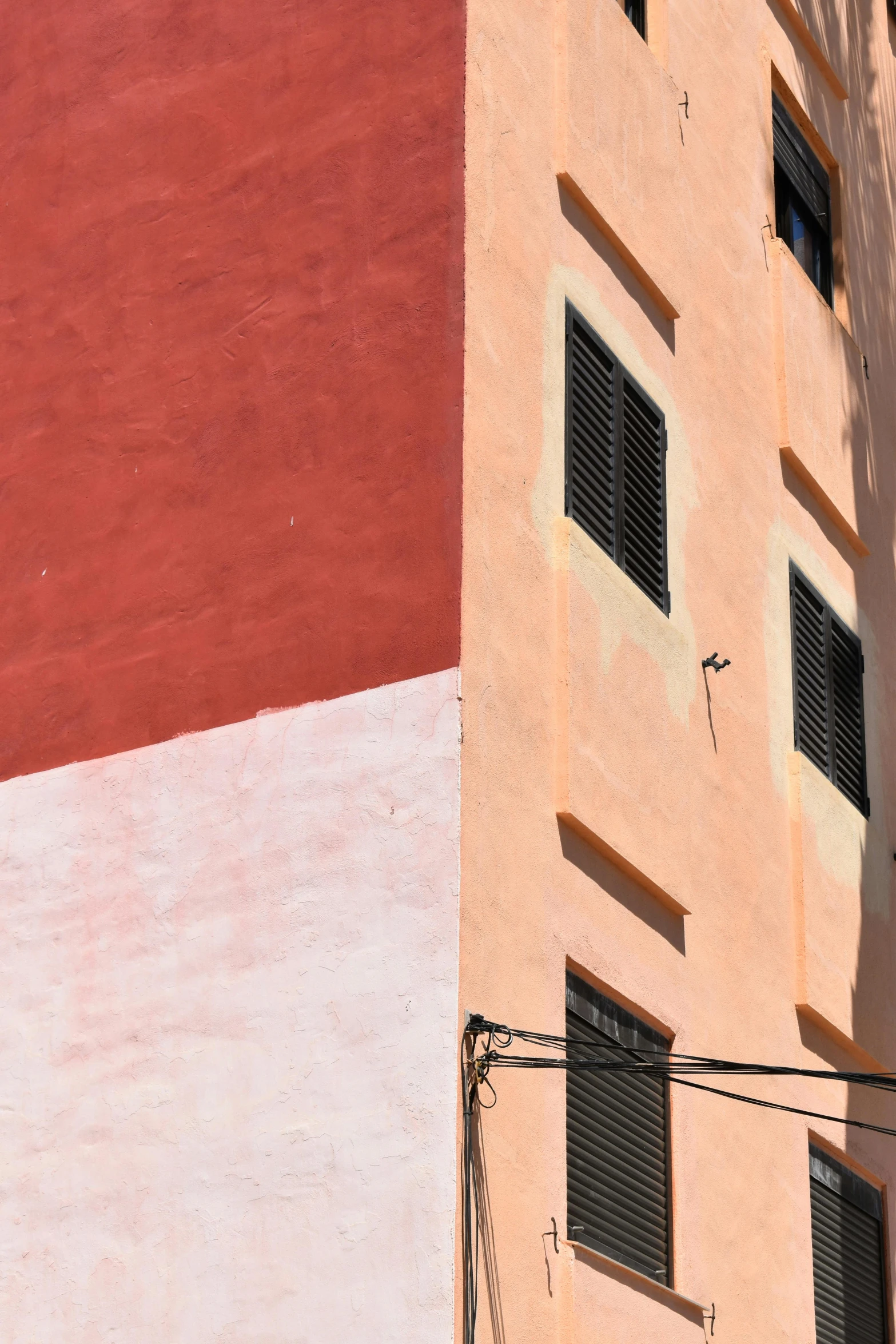 an orange and pink building has many windows