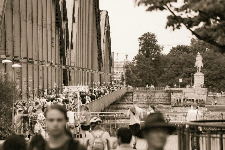 crowd of people walking on a street by a fountain