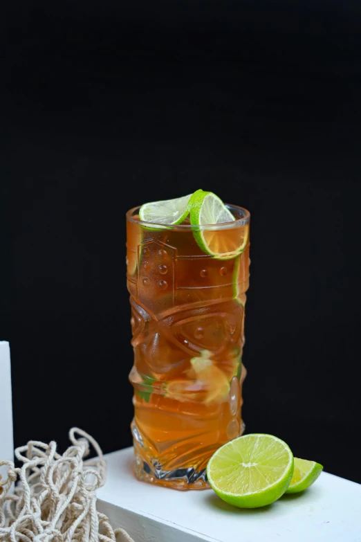 a glass with drink and lime on a table