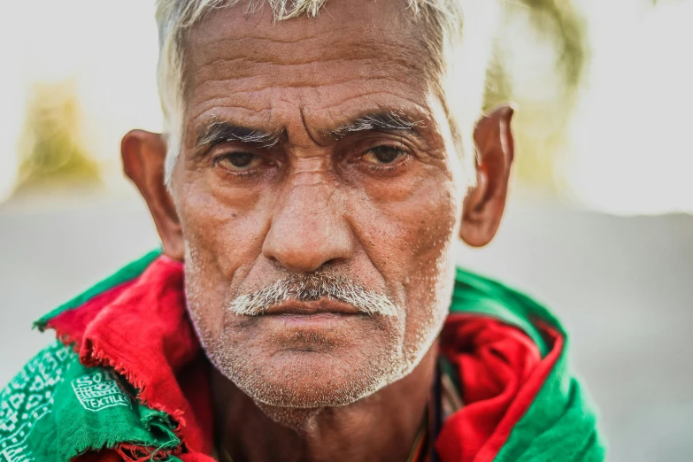 a man is wearing a green, red and white jacket