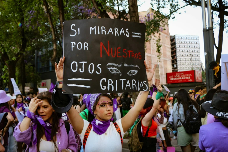 woman protesting outside with sign that says sri miraaras