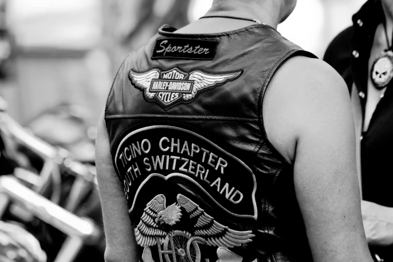 a biker wears a leather vest with badges on it