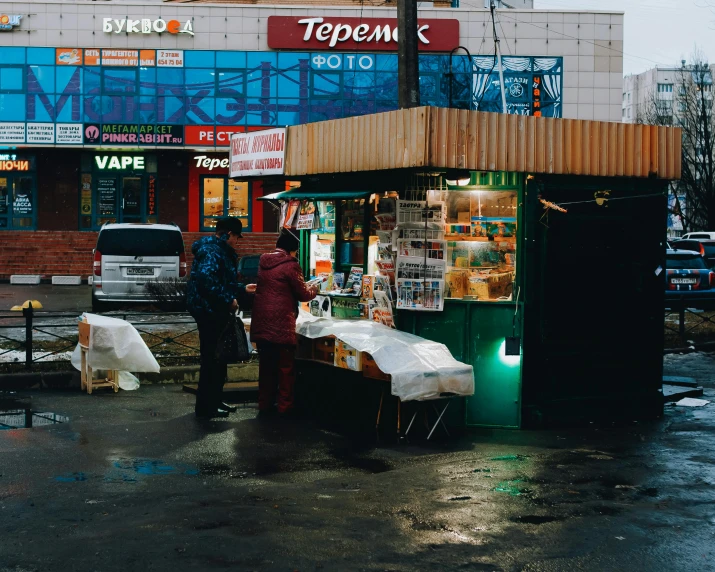 a small storefront with water on the street in front