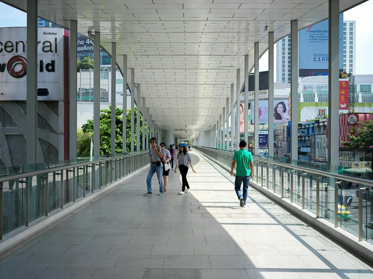 several people are walking down a large bridge