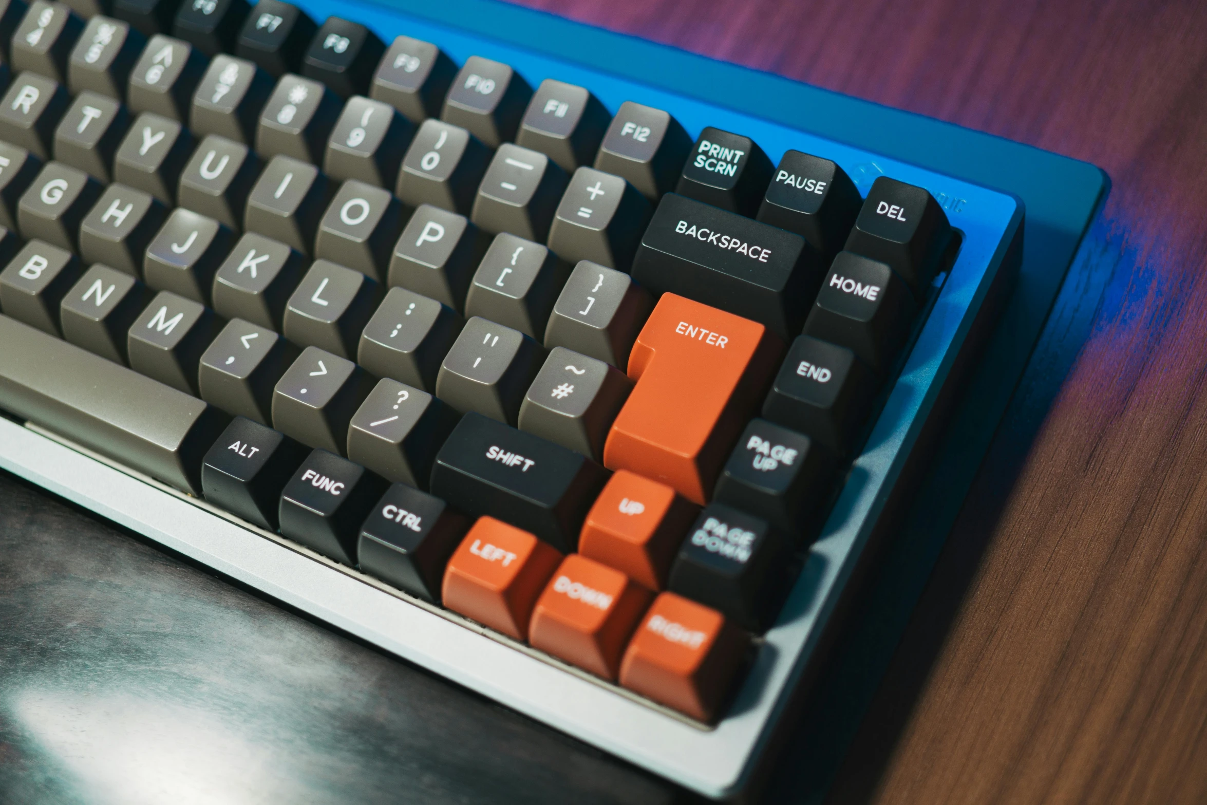 a computer keyboard with an orange keys on a table