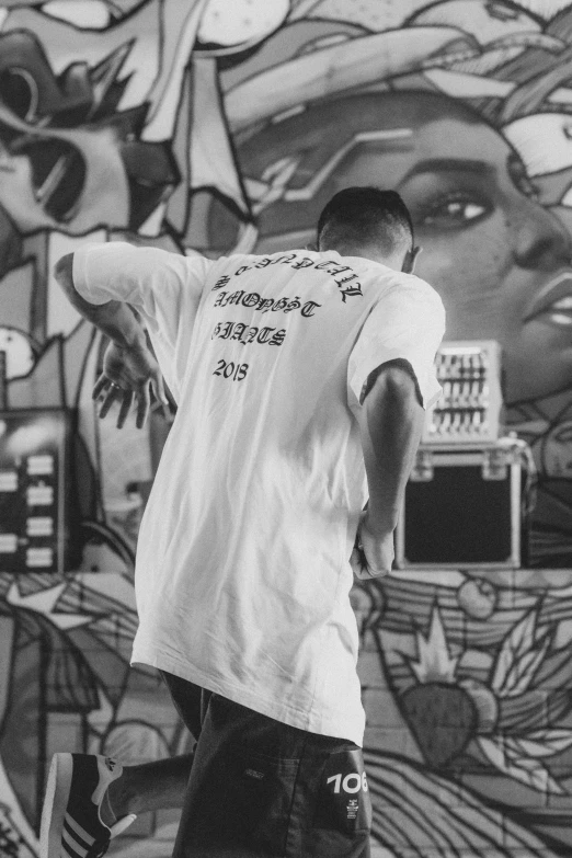 a person standing on a skate board in front of a graffiti wall