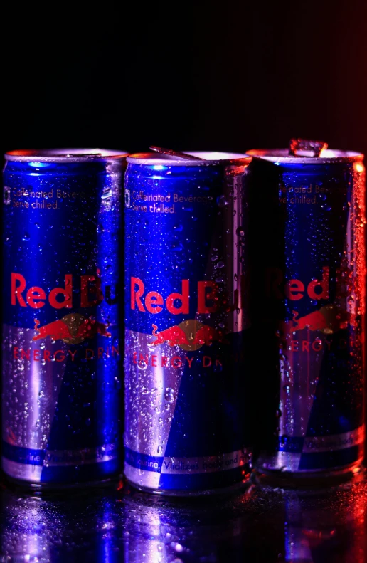 three can of red bull energy drink