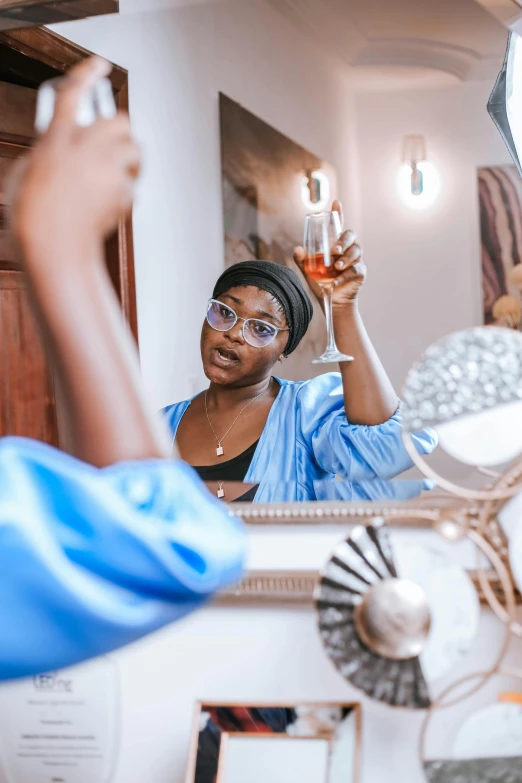 a person with a glass of liquid in her hand