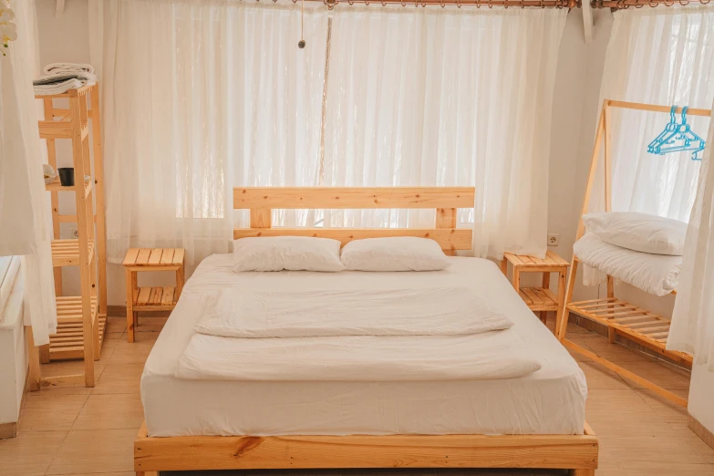 the bed in the room is next to a hanging shelf with two mirrors