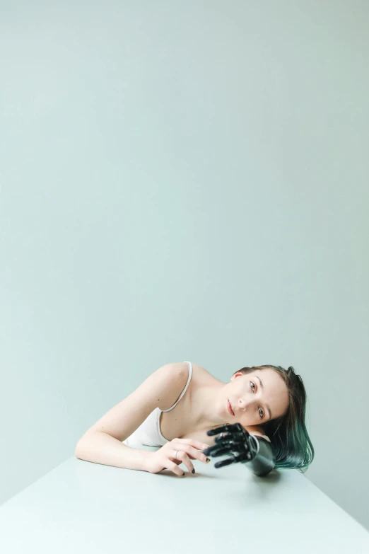 a woman leaning on a table with her hand near her face