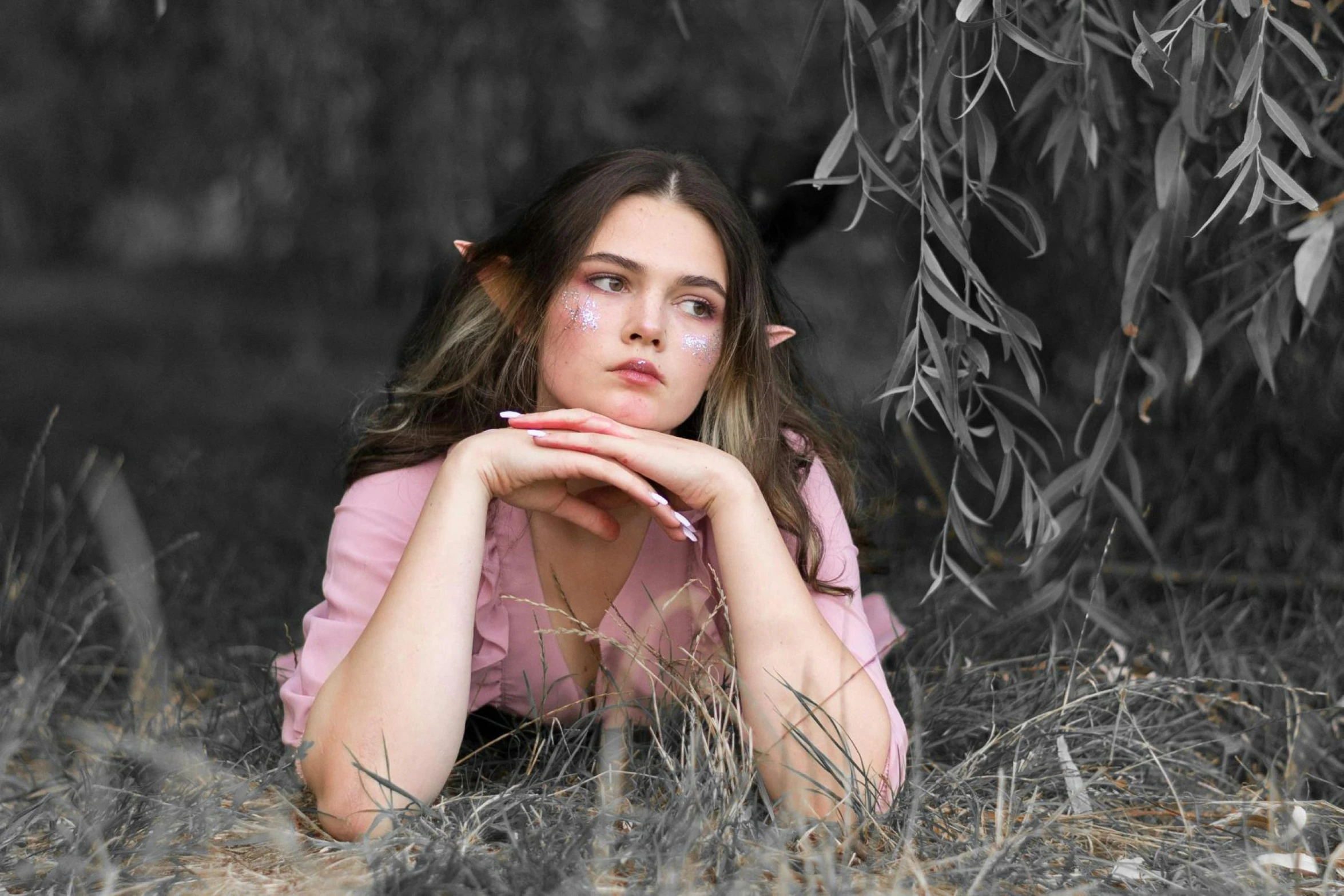 a woman sits in the woods with her hands on her chest