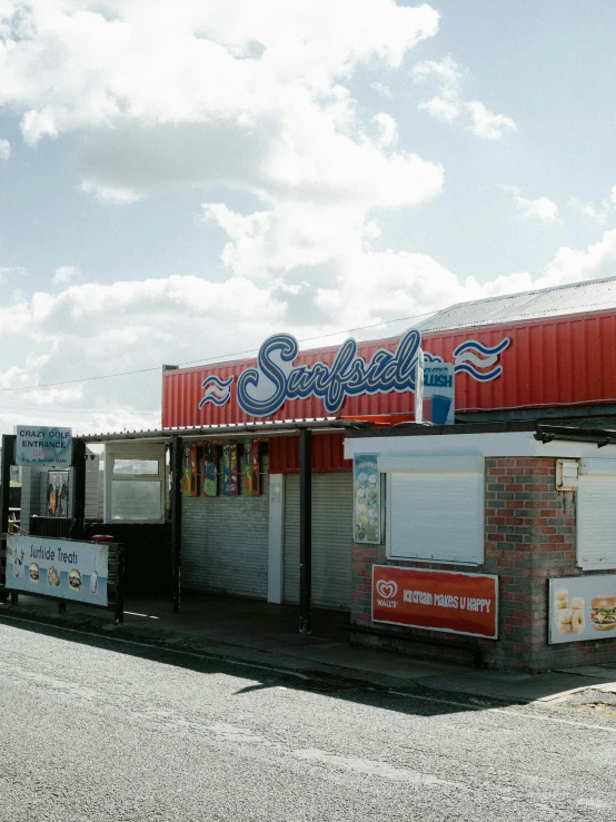 the exterior of a restaurant with red roof and sky background