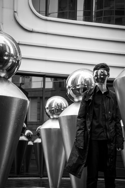 black and white pograph of a man near large metal sculptures