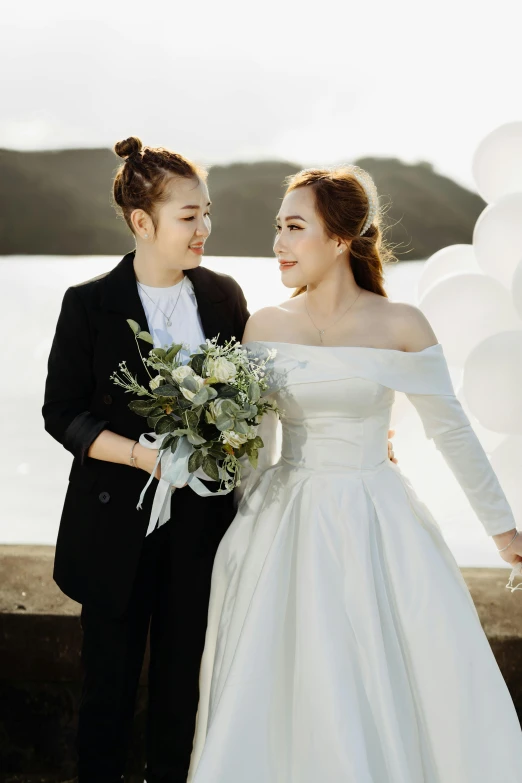 two women in wedding dresses standing next to each other