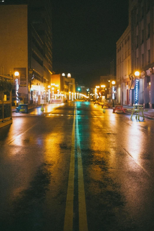 an empty road with rain covered roads and buildings