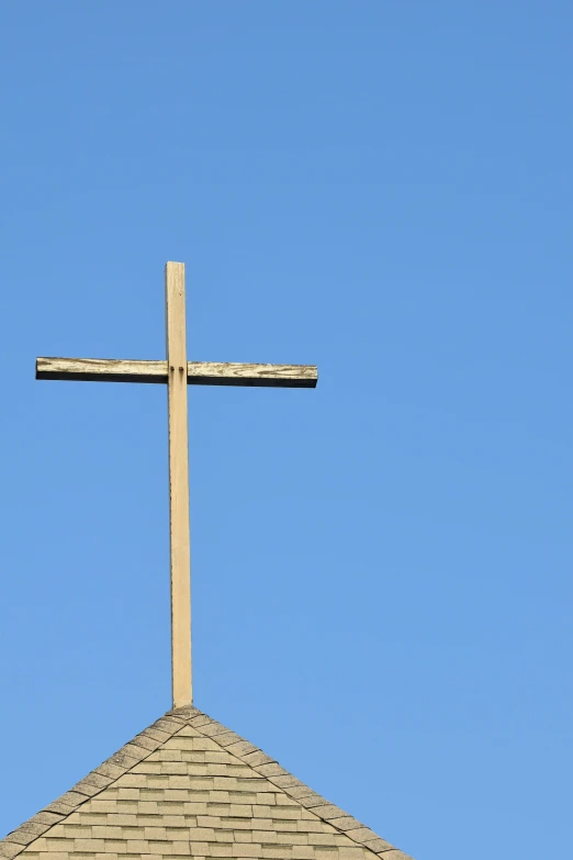 a very large wooden cross on top of a building