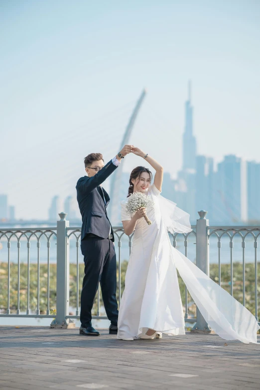 a couple pose for pictures in front of a large city skyline