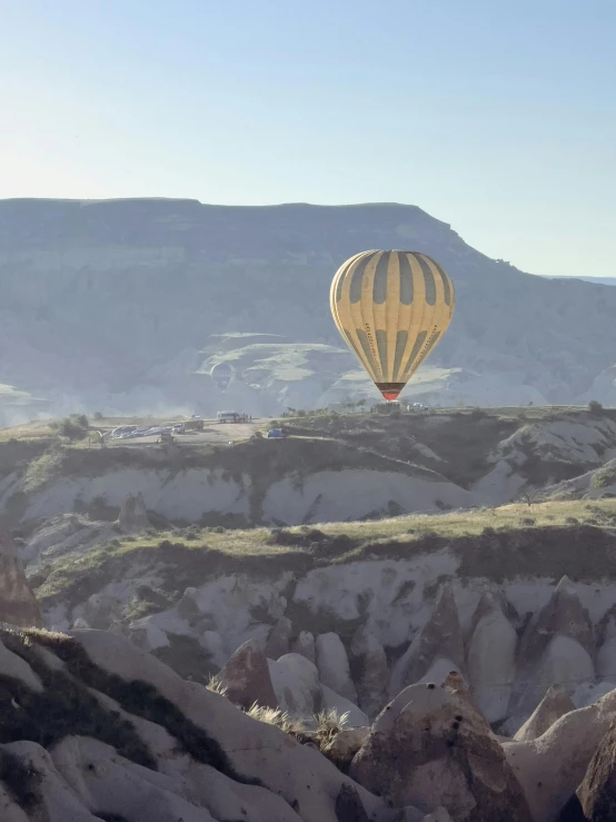  air balloons are being viewed from a hill