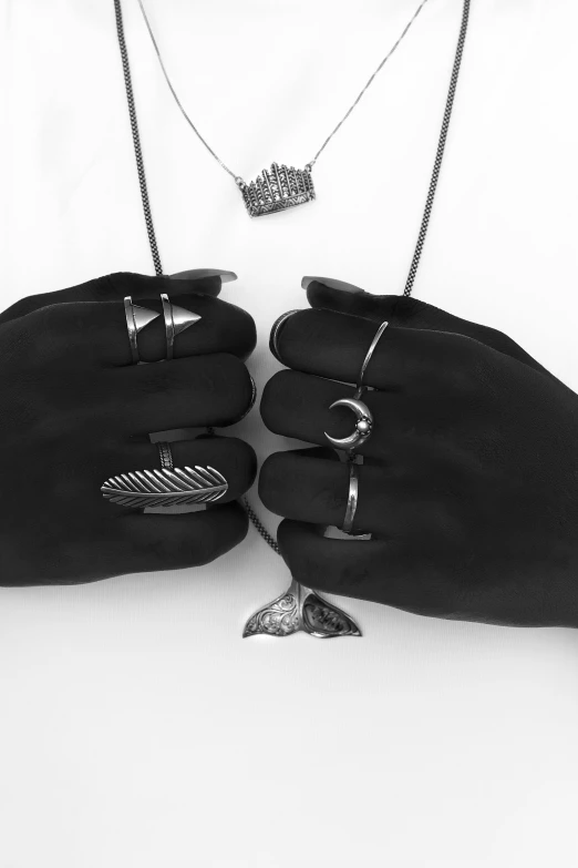 this is an image of a person in black glove holding jewelry