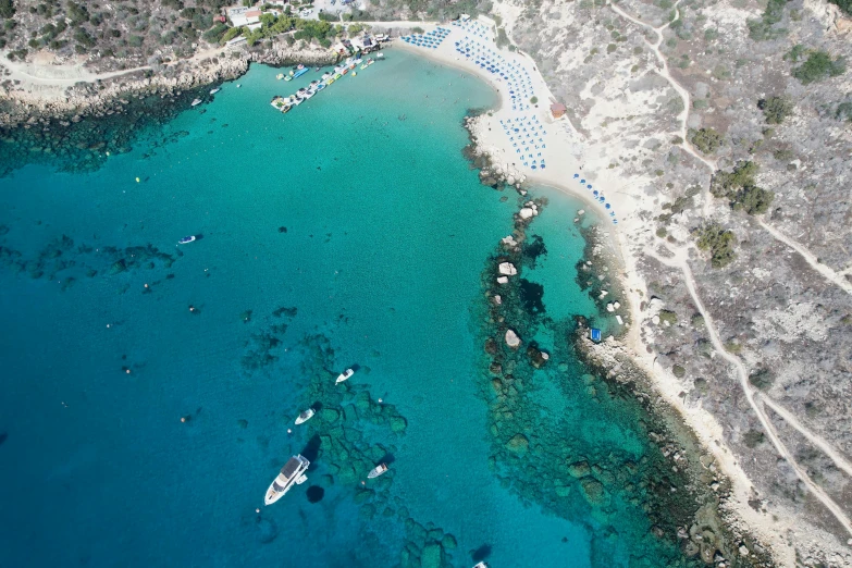 a blue ocean with lots of boats and sandy shoreline