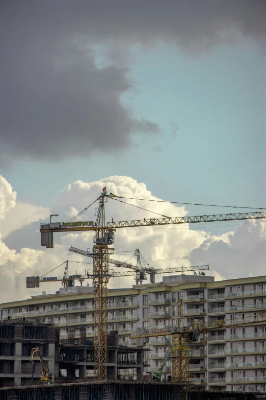 a tall crane is against the cloudy sky