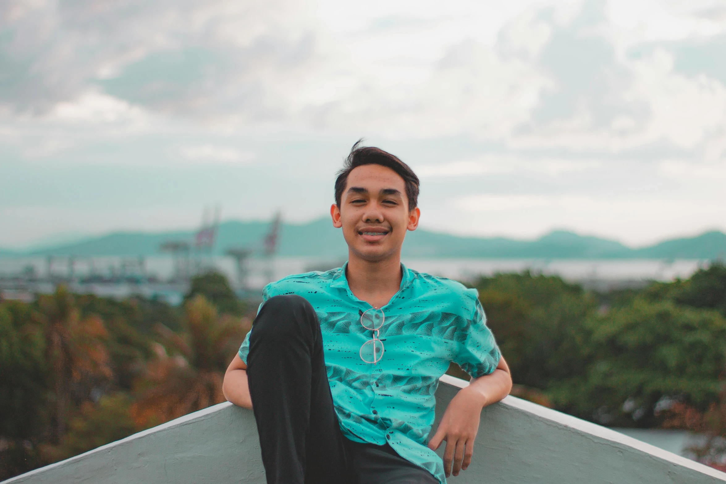 a person sitting on a ledge looking to their right