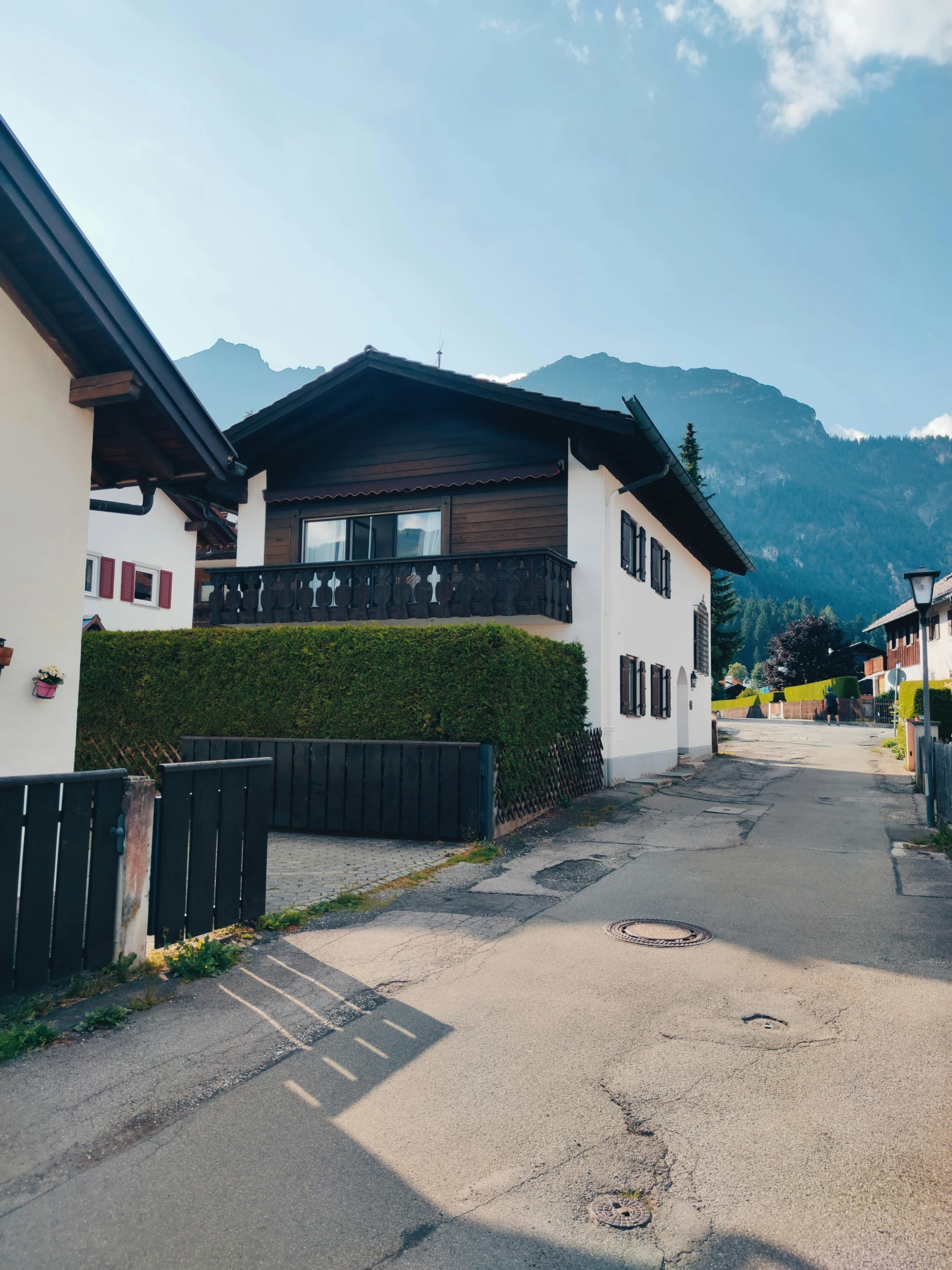 two white and brown house with mountains behind it