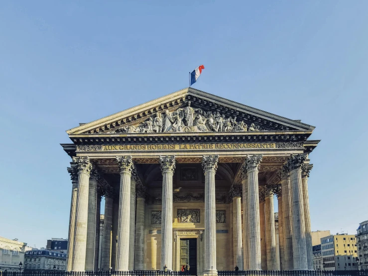 an ornate building with pillars and a flag on top