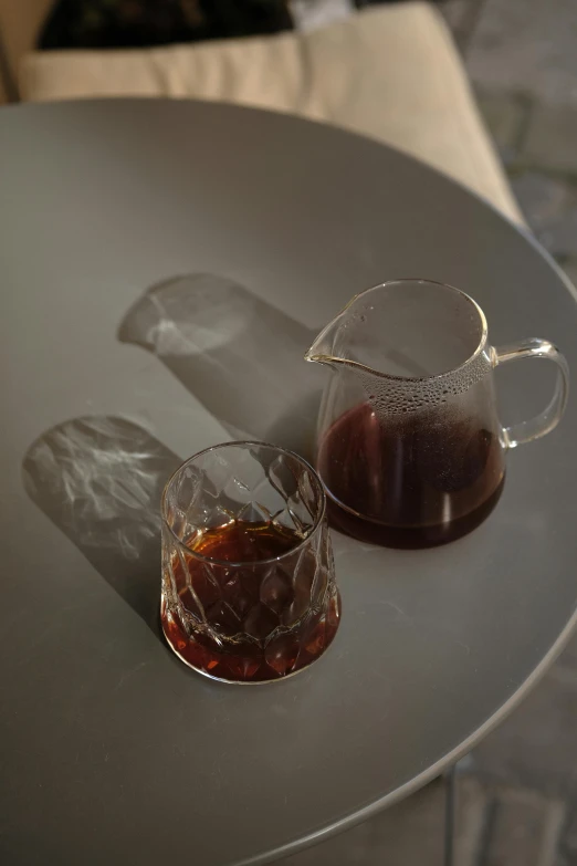 a glass and a decante in front of a white couch