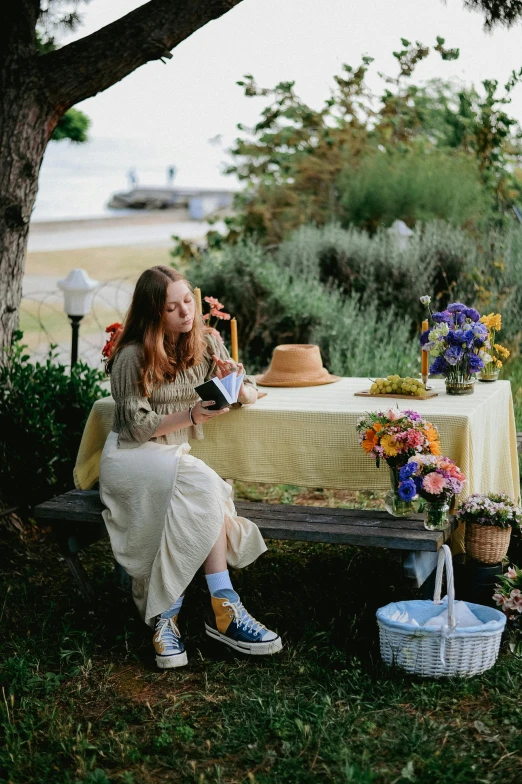 a woman is sitting at a table outdoors