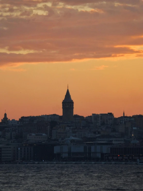 an orange and red sky with a clock tower in the background