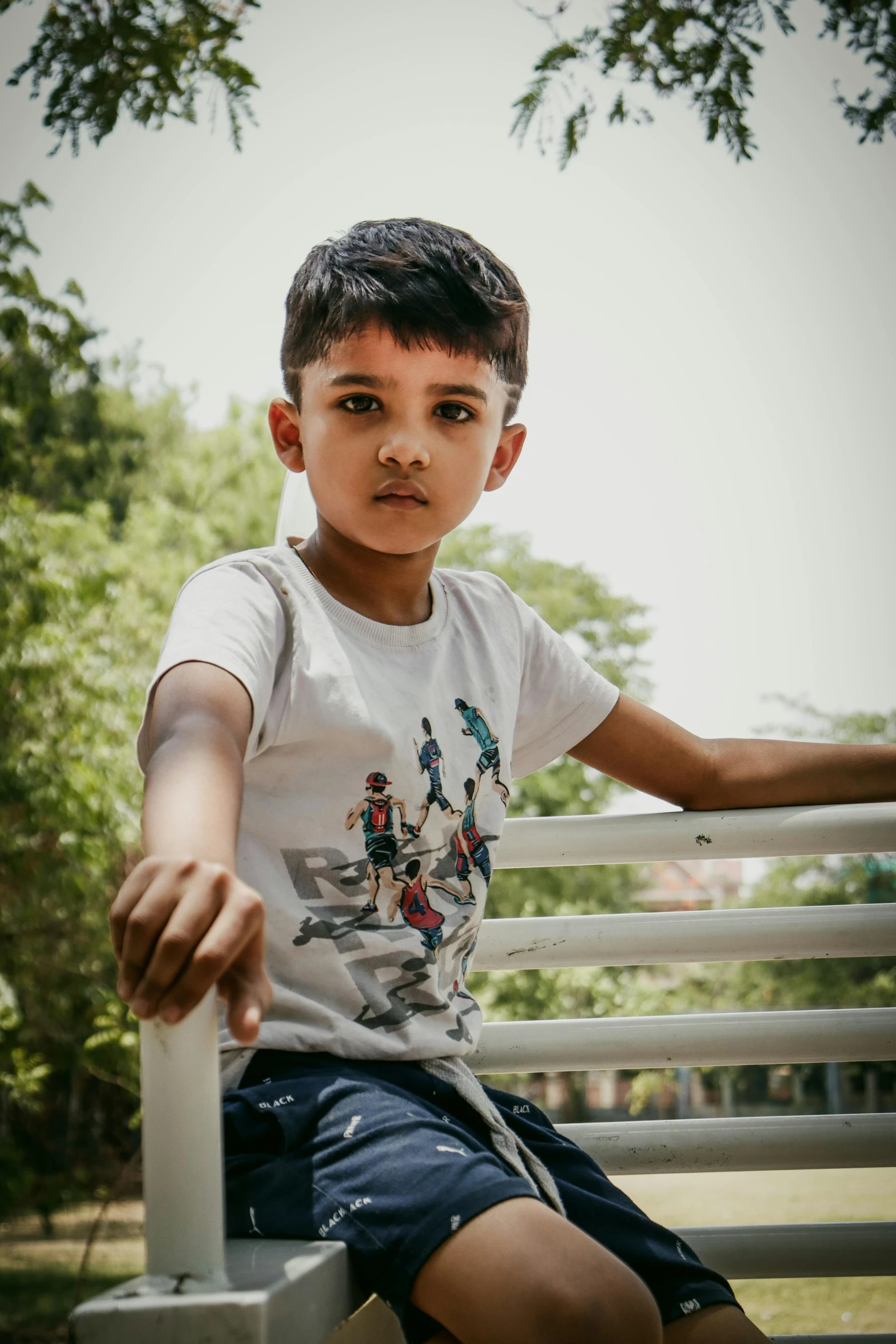 a little boy leaning on a rail with his hand on the rails