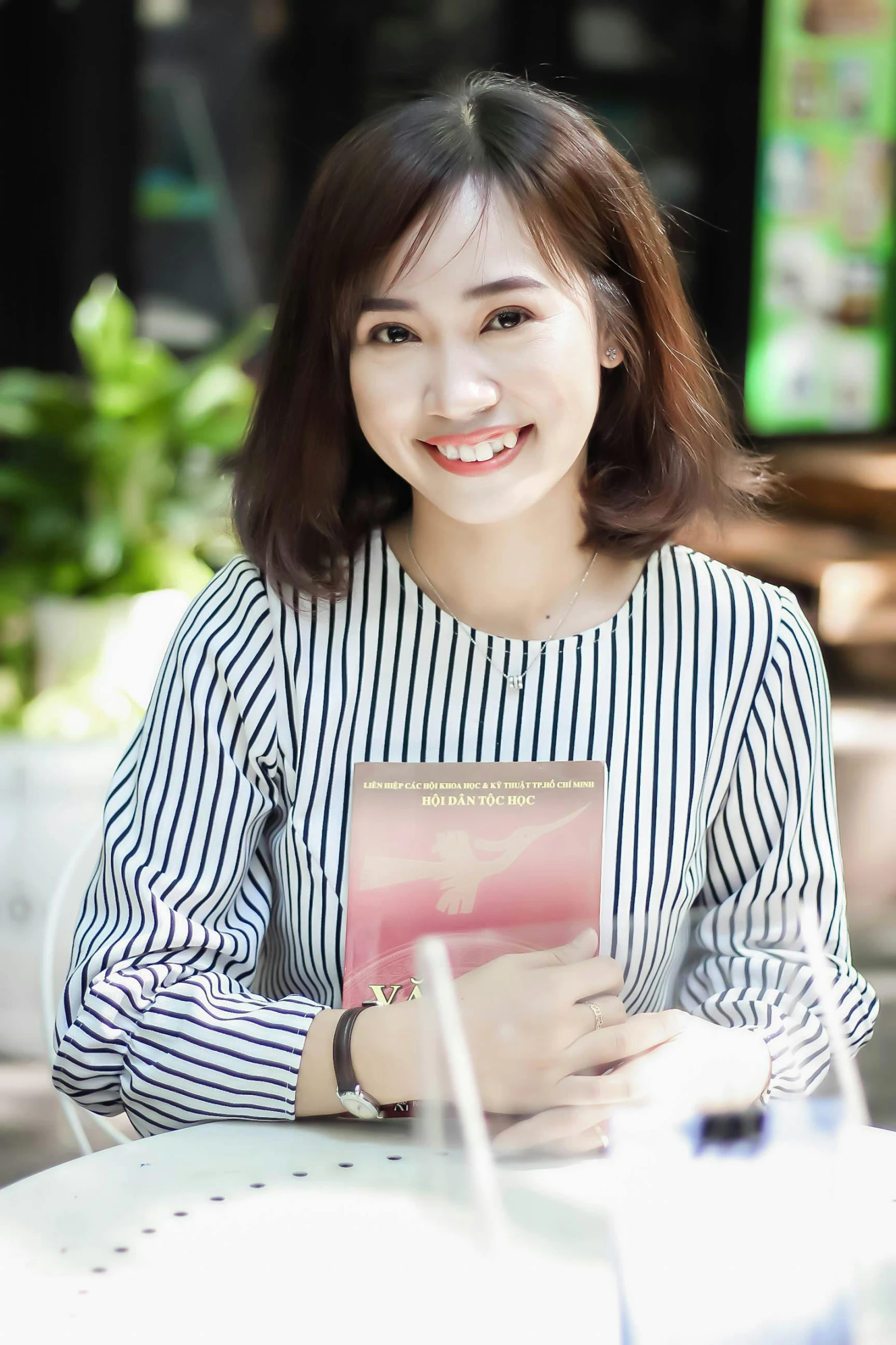 a woman is holding a book and smiling