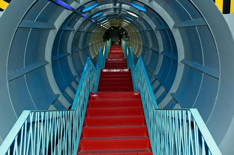 the stairway in the tunnel is empty with lots of red carpet