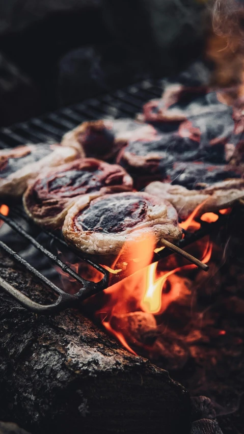 small pizzas are cooking on the charcoal grill