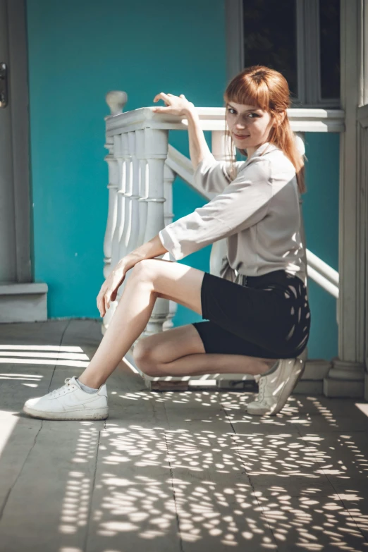 a woman sitting on a step with a chair in the background