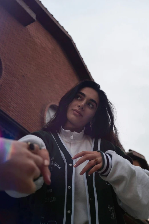 a woman standing in front of a building holding a white remote control