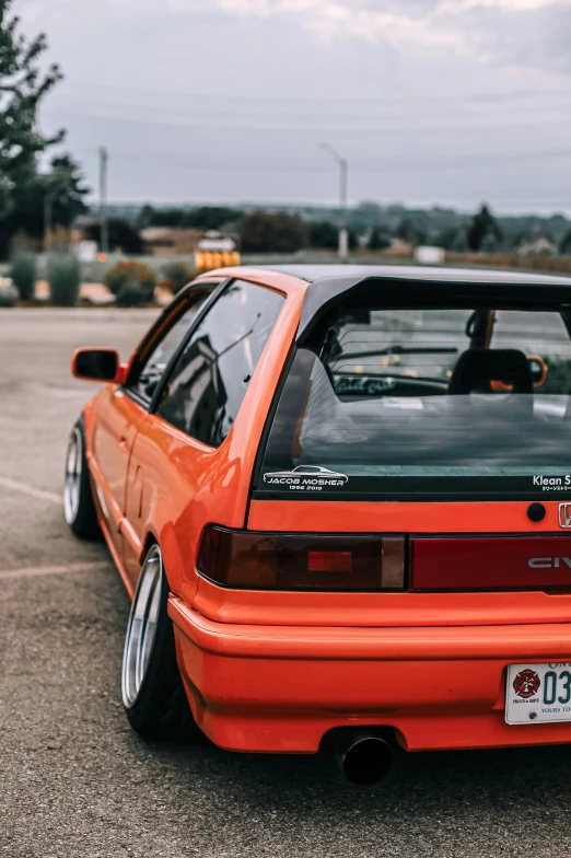 an orange toyota celica gti parked in a parking lot