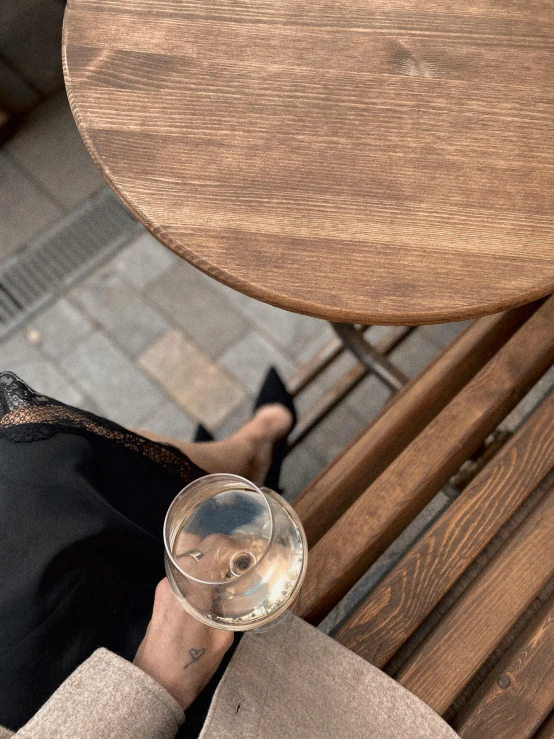 a person in black dress holding a wine glass